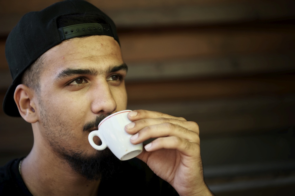 young middle eastern man  drink hot italin coffee