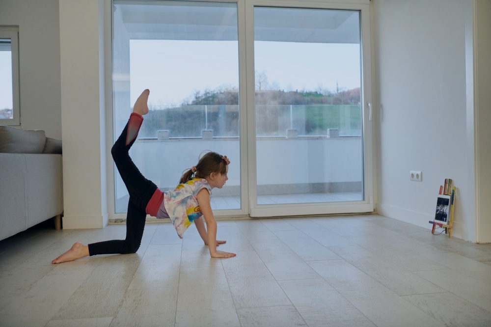 Little girl have online training over  tablet and doing modern ballet dance exercise at home. Online education concept class in modern ballet school. Social distance during quarantine, self-isolation in coronavirus