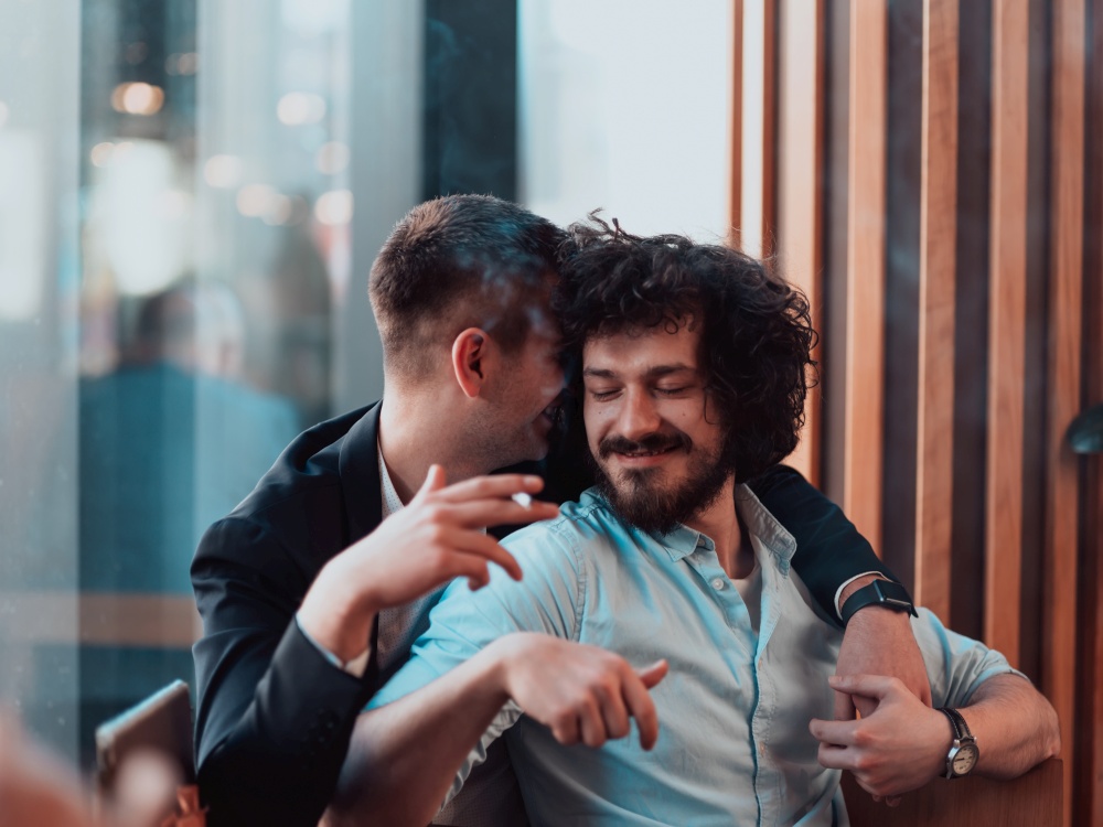 Portrait of multiethnic diverse gay LGBT romantic male couple embracing and showing their love and smoking cigarette. High quality photo. Portrait of multiethnic diverse gay LGBT romantic male couple embracing and showing their love