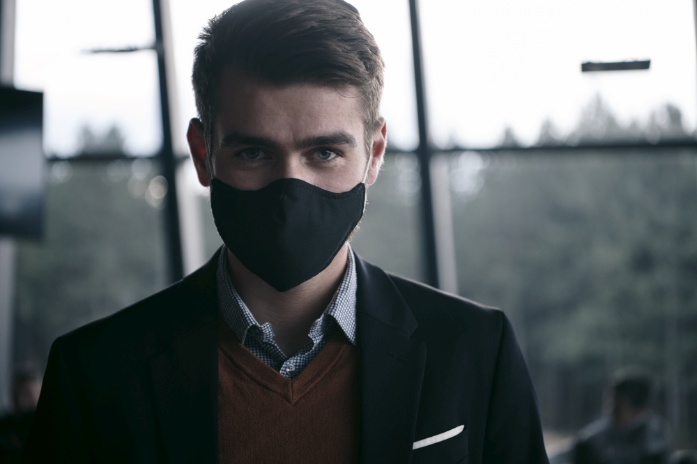 corporate businessman wearing protective medical face mask at modern open space office concept of new normal in business