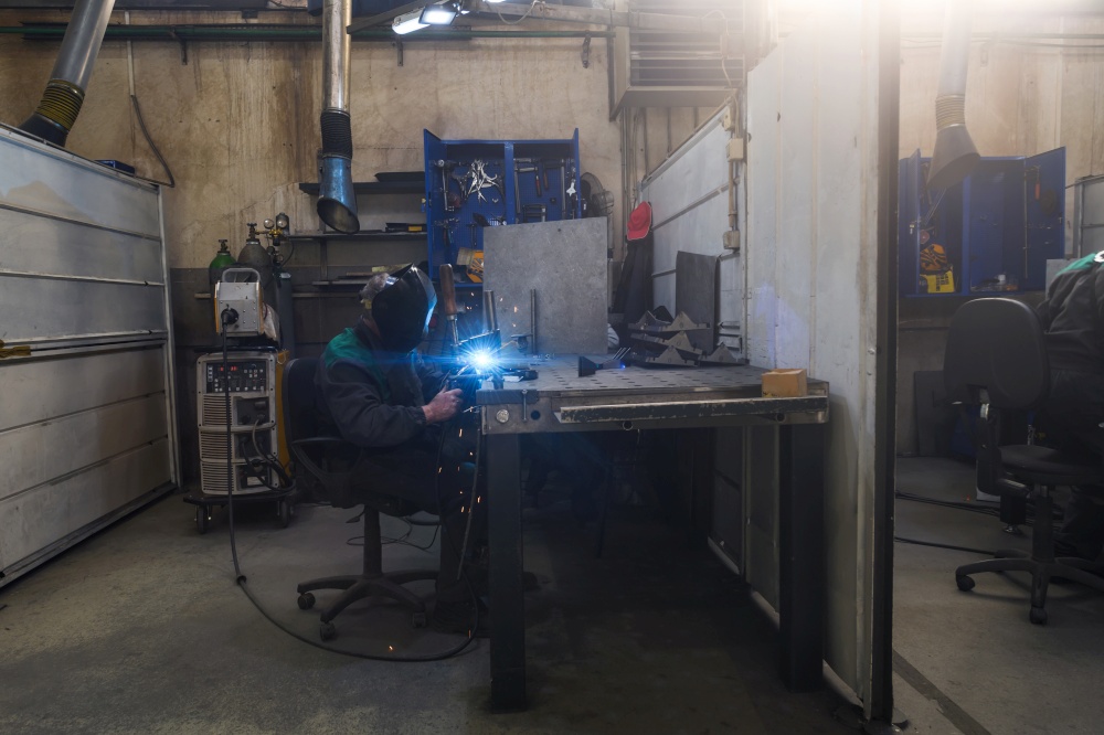 Professional welder performs work with metal parts in factories, sparks, and electricity. Industry worker banner. High quality photo. Professional welder performs work with metal parts in factory, sparks and electricity. Industry worker banner.
