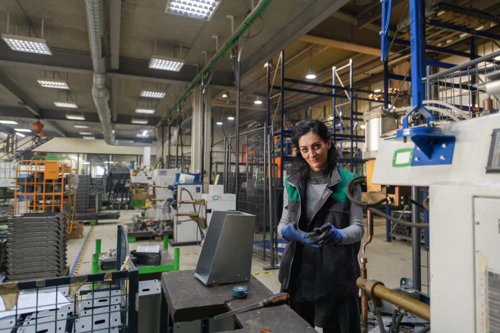 a woman working in a modern metal factory assembles parts for a new machine. High quality photo. a woman working in a modern metal factory assembles parts for a new machine