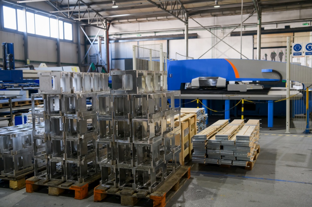 The first phase of metal and aluminum processing. Processed products from CNC machines stacked on a pallet in a large modern factory. High quality photo. The first phase of metal and aluminum processing. Processed products from CNC machines stacked on a pallet in a large modern factory