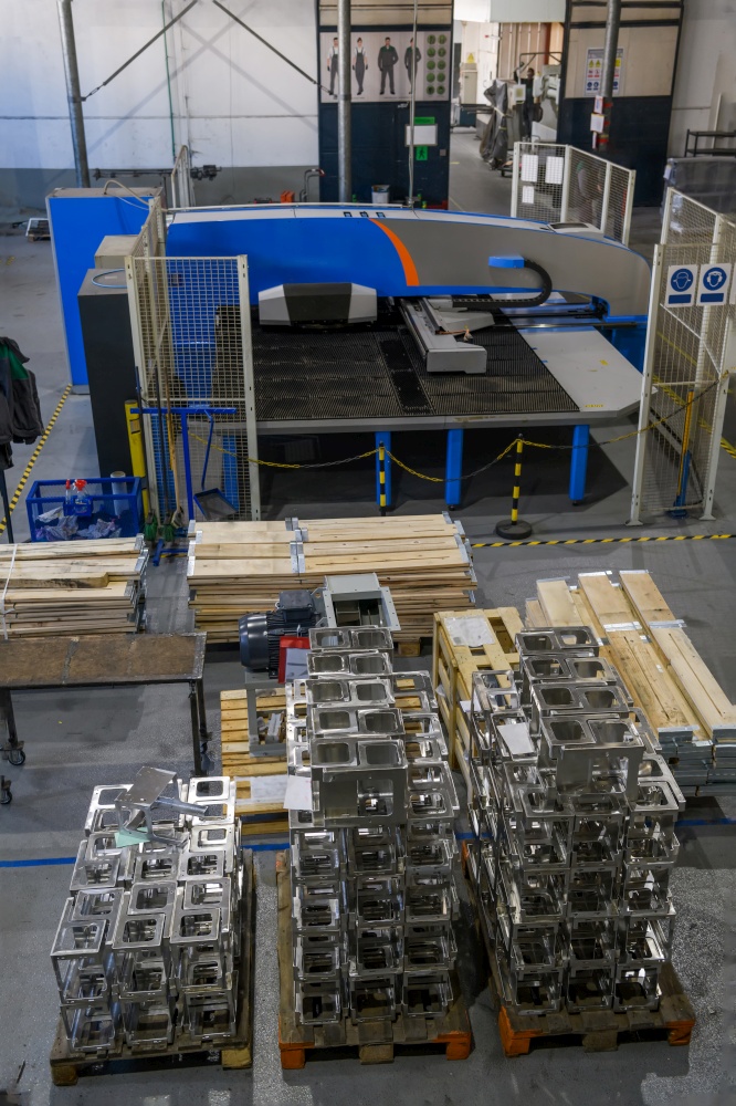 The first phase of metal and aluminum processing. Processed products from CNC machines stacked on a pallet in a large modern factory. High quality photo. The first phase of metal and aluminum processing. Processed products from CNC machines stacked on a pallet in a large modern factory