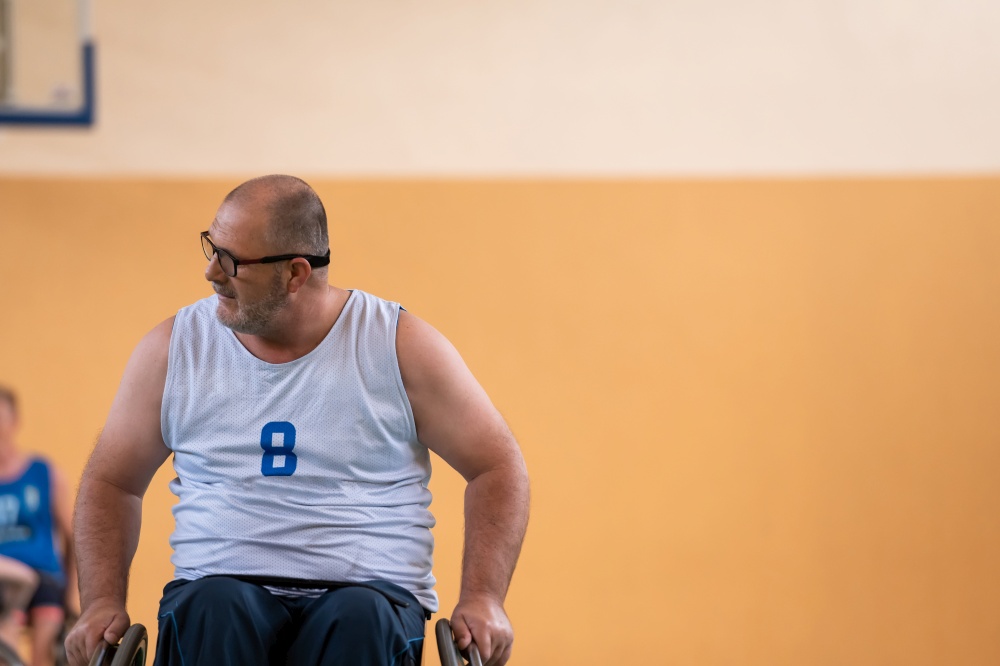 a photo of a war veteran playing basketball with a team in a modern sports arena. The concept of sport for people with disabilities. High quality photo. a photo of a war veteran playing basketball with a team in a modern sports arena. The concept of sport for people with disabilities
