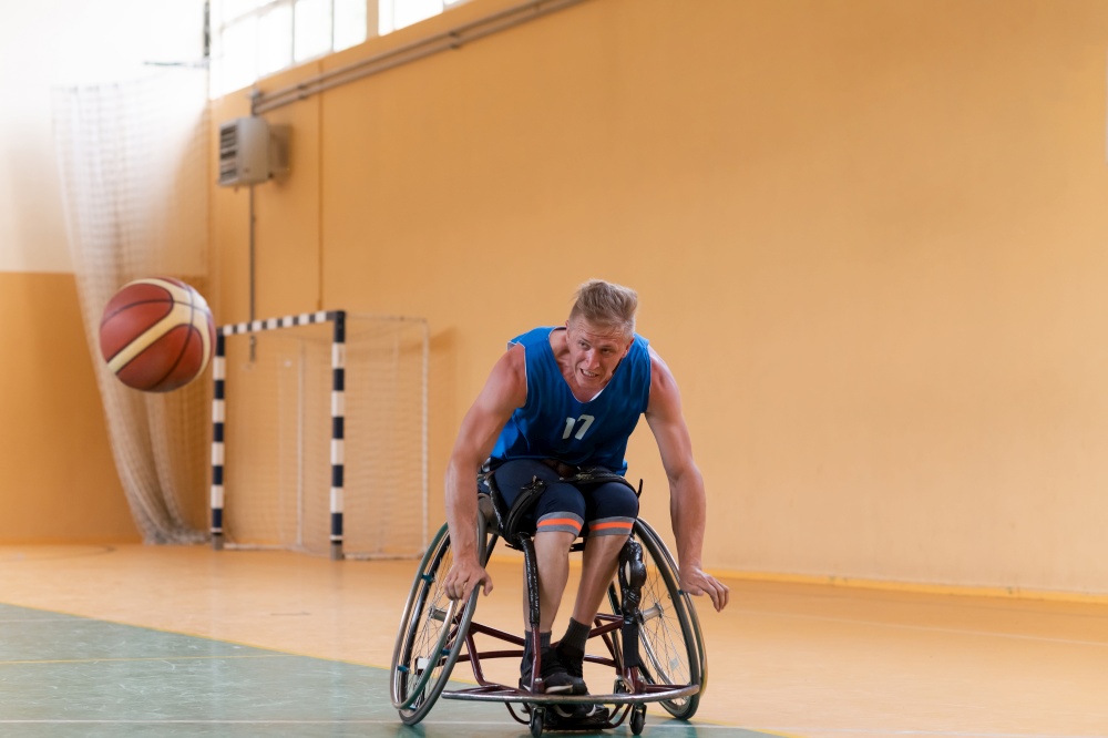 disabled war veterans in action while playing basketball on a basketball court with professional sports equipment for the disabled. High quality photo. disabled war veterans in action while playing basketball on a basketball court with professional sports equipment for the disabled