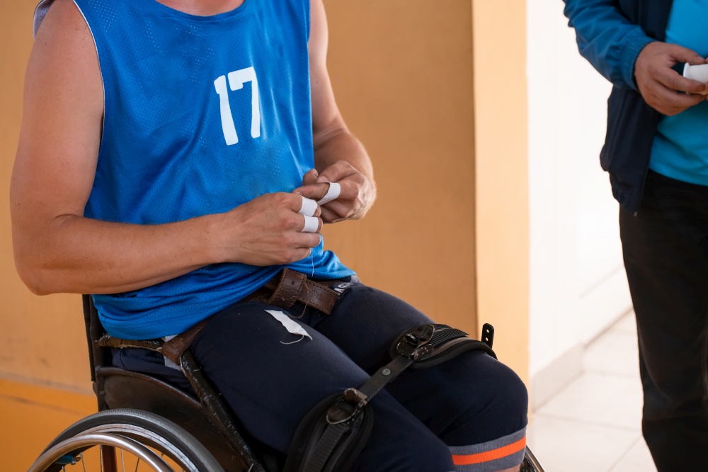 a handicapped basketball player prepares for a match while sitting in a wheelchair. preparations for a professional basketball match. the concept of disability sport. High quality photo. a handicapped basketball player prepares for a match while sitting in a wheelchair.preparations for a professional basketball match. the concept of disability sport