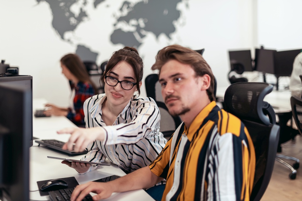 Business couple working together on a project using tablet and desktop computer at modern open plan startup office. Selective focus. High-quality photo. Business couple working together on project using tablet and desktop computer at modern open plan startup office. Selective focus