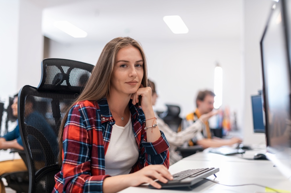 Casual businesswoman working on a desktop computer in modern open plan startup office interior. Selective focus. High-quality photo. Casual business woman working on desktop computer in modern open plan startup office interior. Selective focus