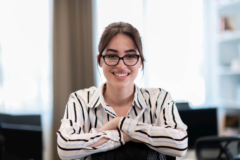 Portrait of businesswoman in casual clothes with glasses at modern startup open plan office interior. Selective focus. High-quality photo. Portrait of businesswoman in casual clothes with glasses at modern startup open plan office interior. Selective focus
