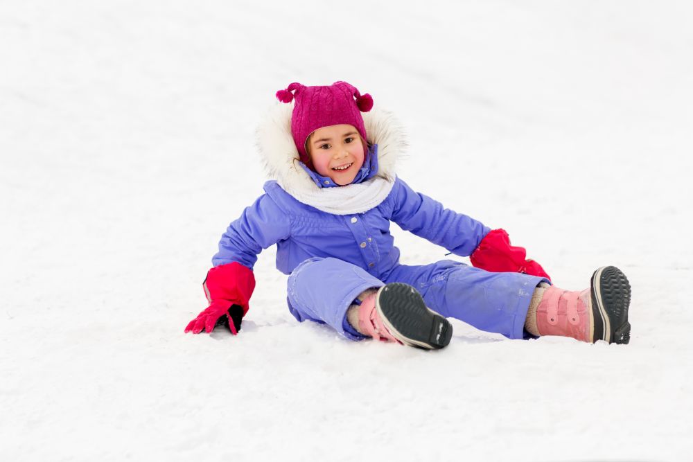 childhood, leisure and season concept - happy little girl in winter clothes outdoors. happy little girl in winter clothes outdoors