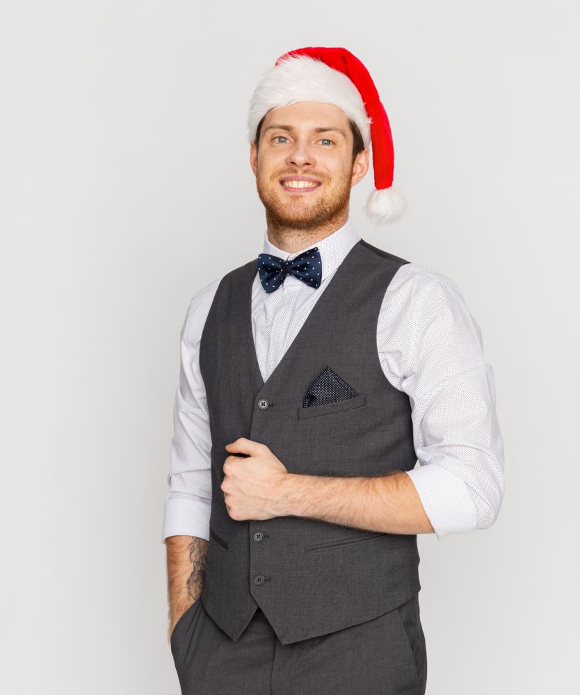 celebration, people and holidays concept - happy man in santa hat and suit at christmas. happy man in santa hat and suit at christmas