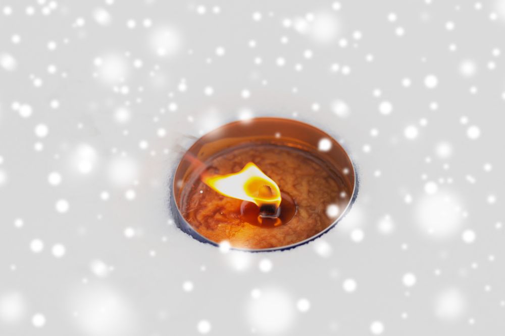 winter holidays and christmas concept - outdoor candle burning on snow. christmas outdoor candle burning on snow in winter