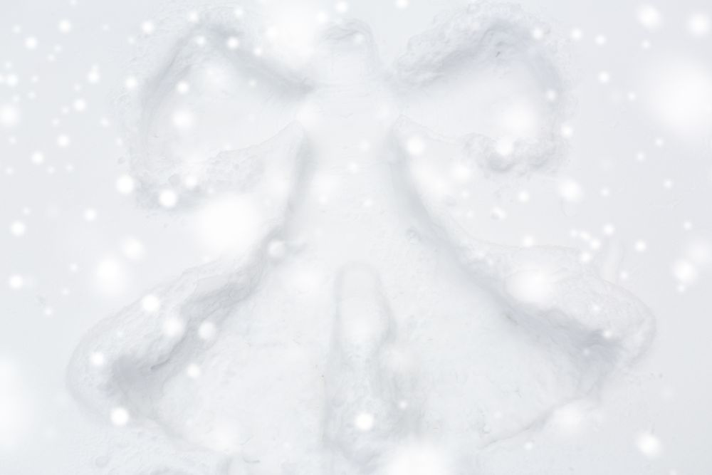 winter holidays and christmas concept - angel silhouette or print on snow surface. angel silhouette or print on snow surface
