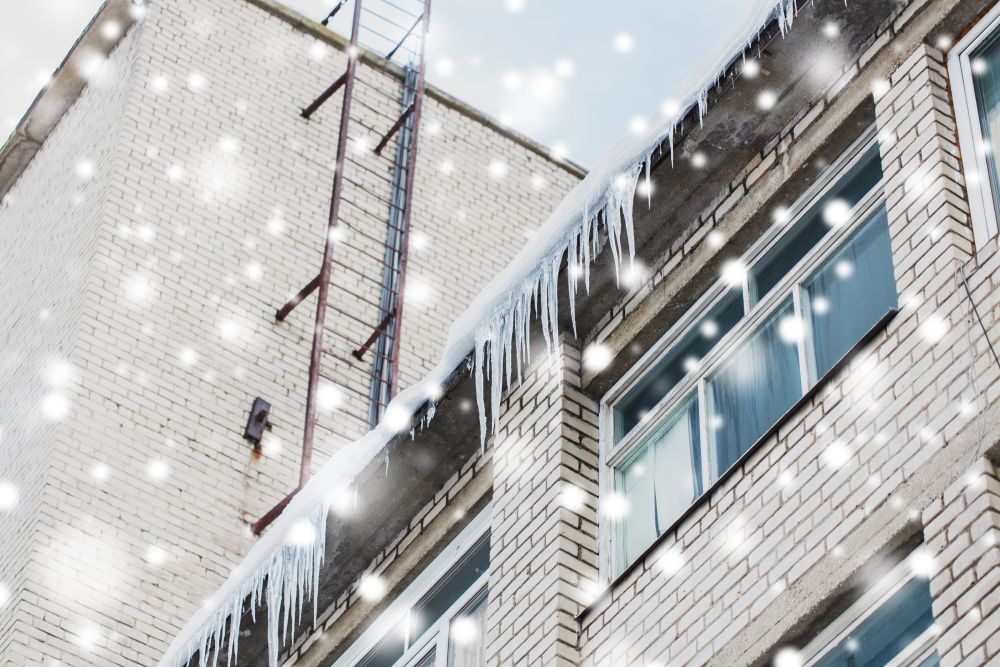 season, housing and winter concept - icicles on building or living house facade. icicles on building or living house facade