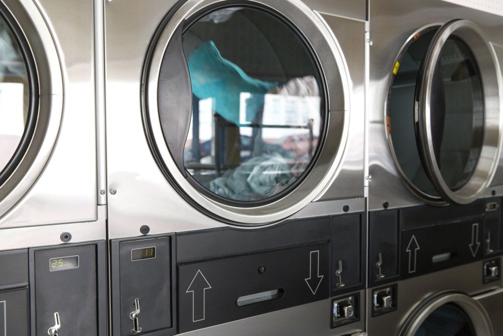 self-service laundry facilities concept - washing machines with clothes inside at laundromat. washing machines with clothes inside at laundromat