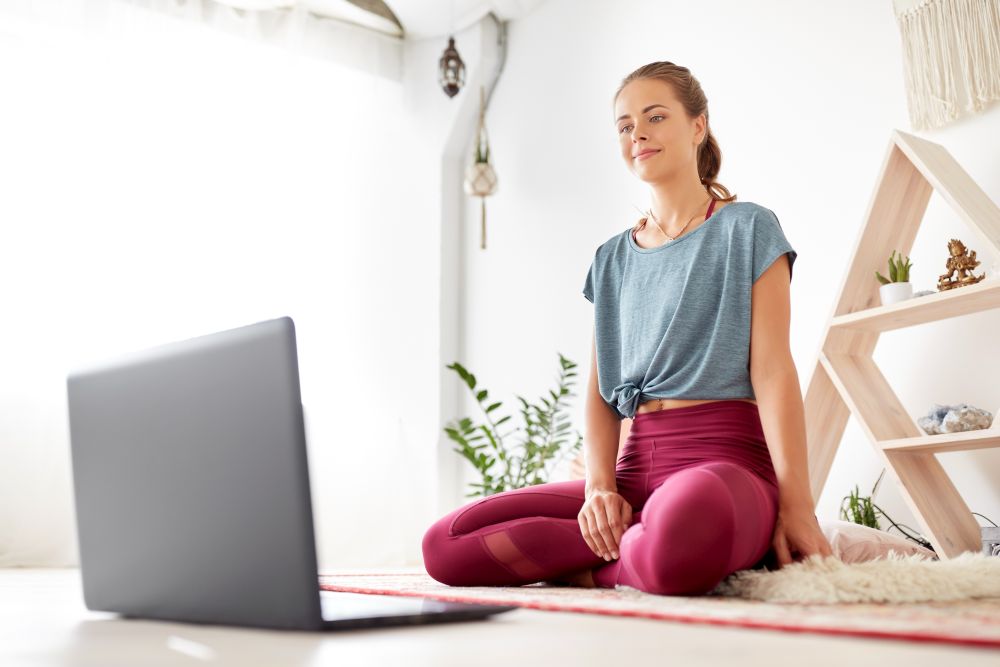 fitness, technology and healthy lifestyle concept - woman with laptop computer at yoga studio. woman with laptop computer at yoga studio