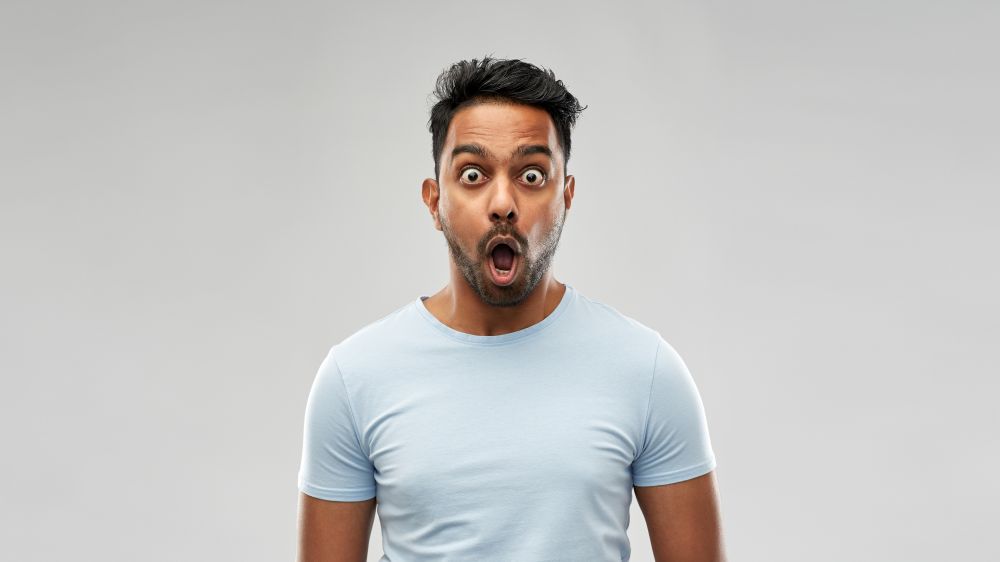 emotion, expression and people concept - shocked or scared man in t-shirt over grey background. shocked or scared man over grey background