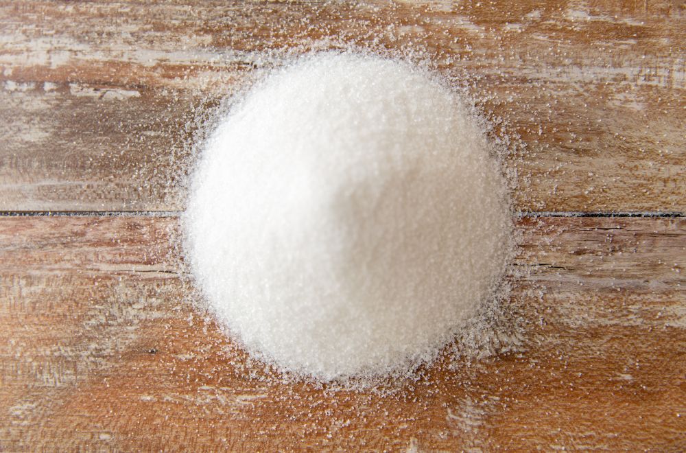 food, junk-food, cooking and unhealthy eating concept - close up of white sugar heap on wooden table. close up of white sugar heap on wooden table