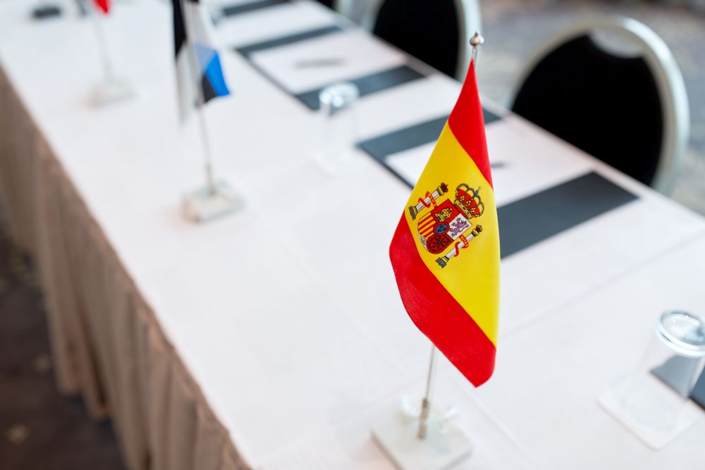 business, corporate and interior concept - flags on table in boardroom at international conference. flags at international conference boardroom