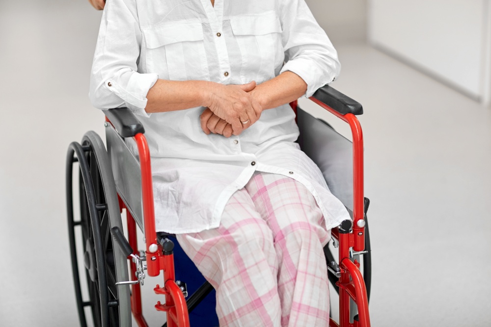medicine, health and care concept - senior woman patient in wheelchair at hospital corridor or nursing home. senior woman patient in wheelchair at hospital