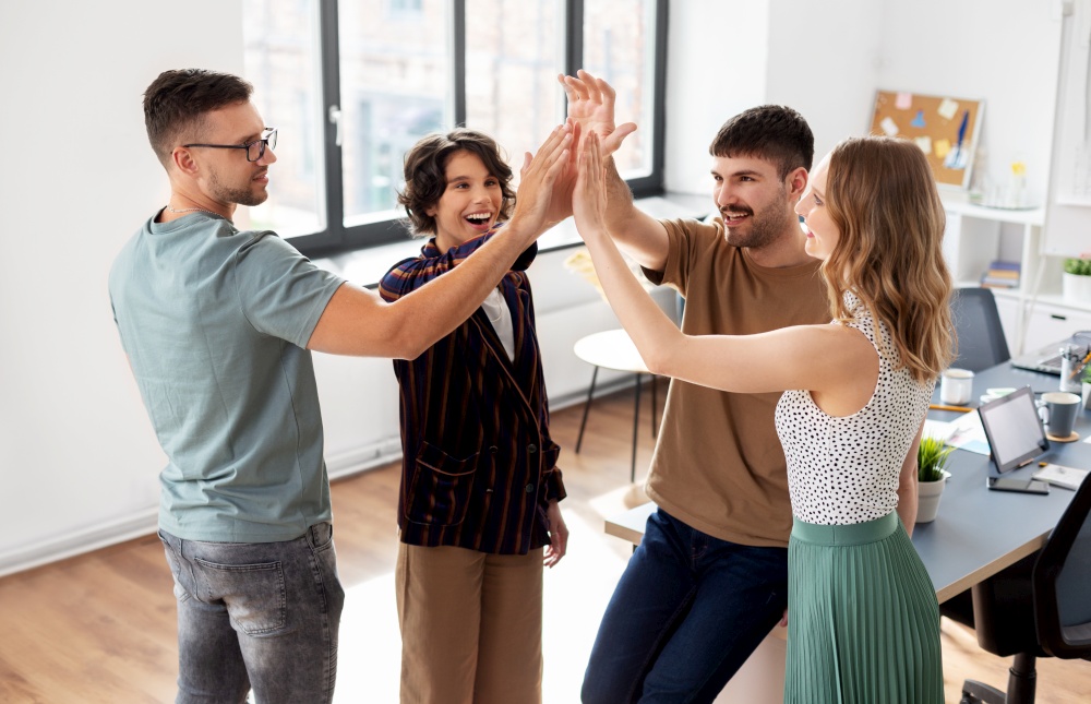 startup, success and people concept - happy business team making high five at office. happy business team making high five at office