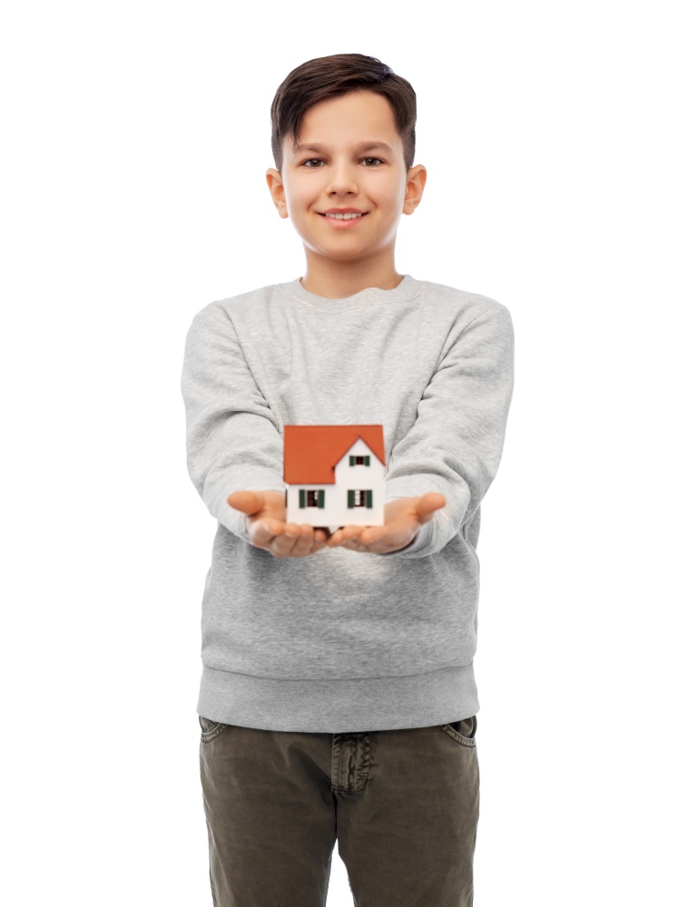 mortgage, real estate and accommodation concept - smiling boy holding house model over white background. smiling boy holding house model