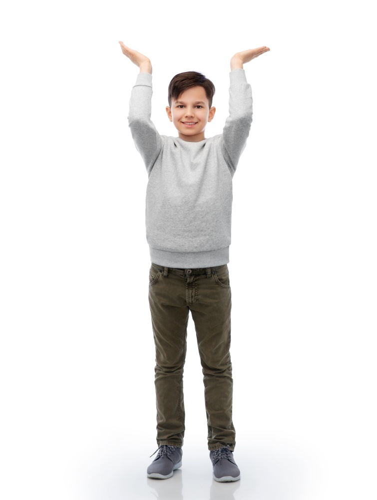 childhood, fashion and people concept - happy smiling boy holding something imaginary over white background. happy smiling boy holding something imaginary