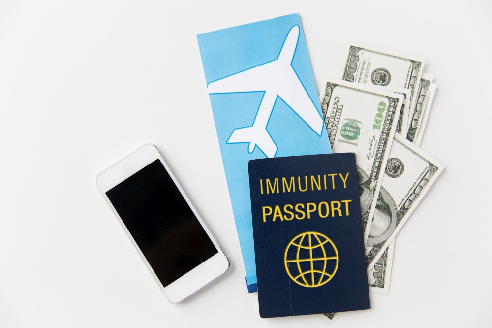 tourism, safe travel and health care concept - immunity passport, air ticket, money and smartphone on white background. immunity passport and air tickets for travel