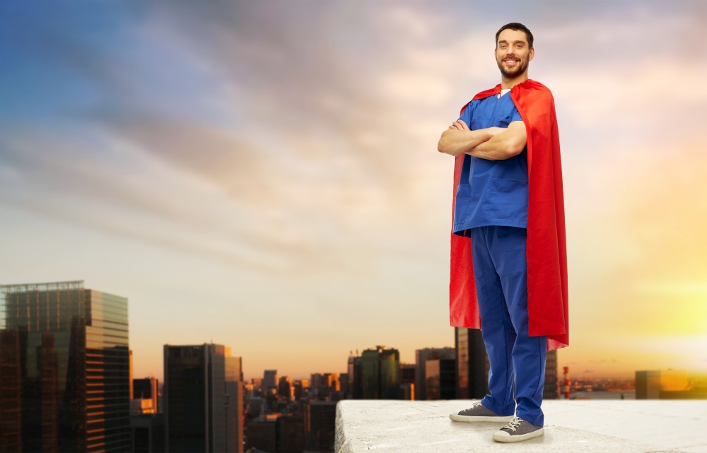 healthcare, profession and medicine concept - happy smiling doctor or male nurse in blue uniform and red superhero cape standing on roof top over sunrise in tokyo city background. doctor or male nurse in superhero cape in city