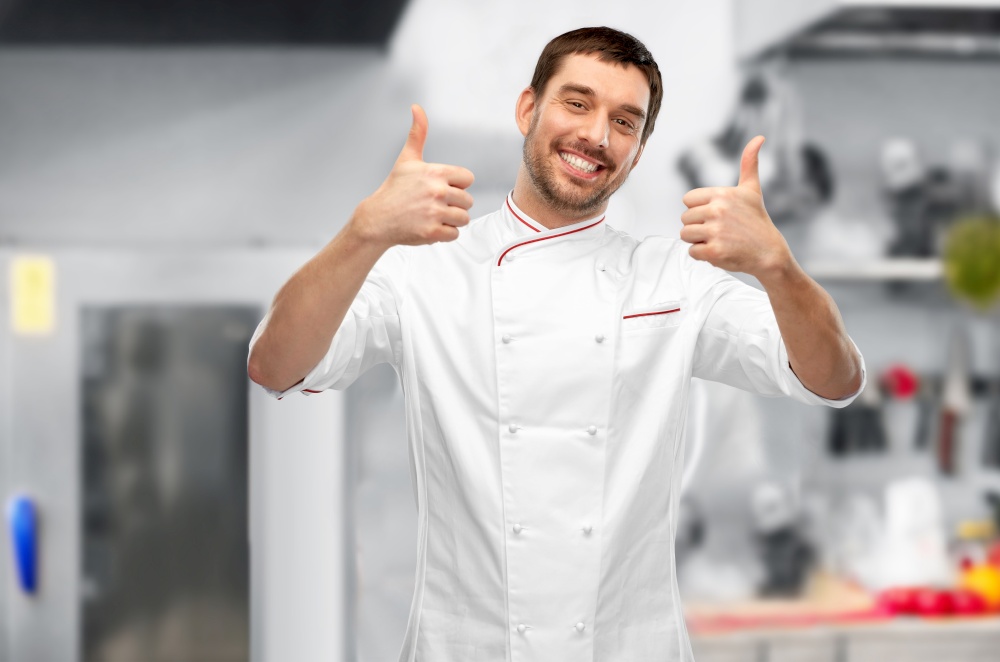 cooking, culinary and people concept - happy smiling male chef in jacket showing thumbs up over grey background. smiling male chef in jacket showing thumbs up