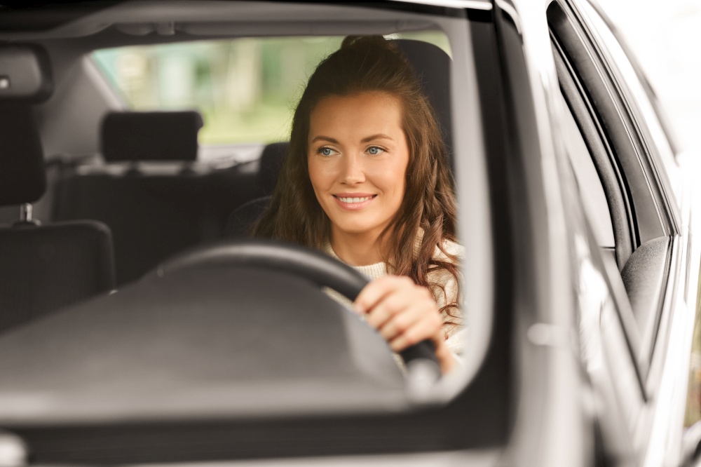 safety and people concept - young woman or female driver driving car in city. woman or female driver driving car in city