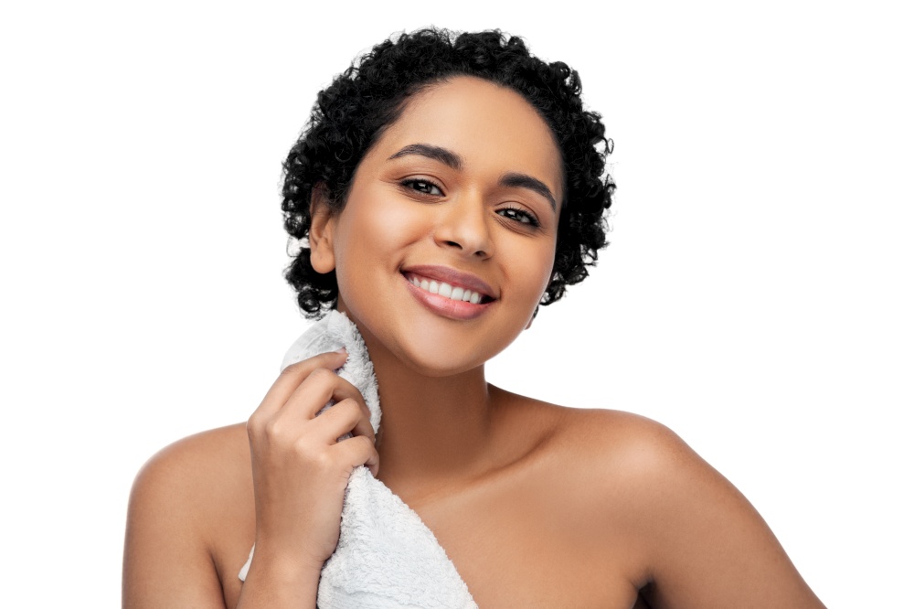 beauty and people concept - portrait of happy smiling young african american woman with bath towel over white background. young african american woman with bath towel