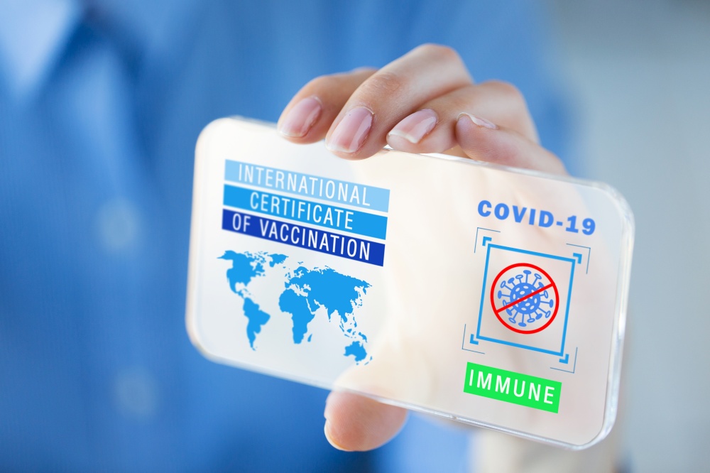 technology and health care concept - close up of woman holding and showing transparent smartphone with international certificate of vaccination or virtual immunity passport on screen. hand with certificate of vaccination on smartphone