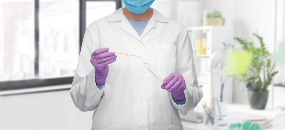medicine, health and coronavirus concept - close up of female doctor in gloves and mask with test tube and cotton swab over medical office at hospital background. female doctor with test tube and cotton swab