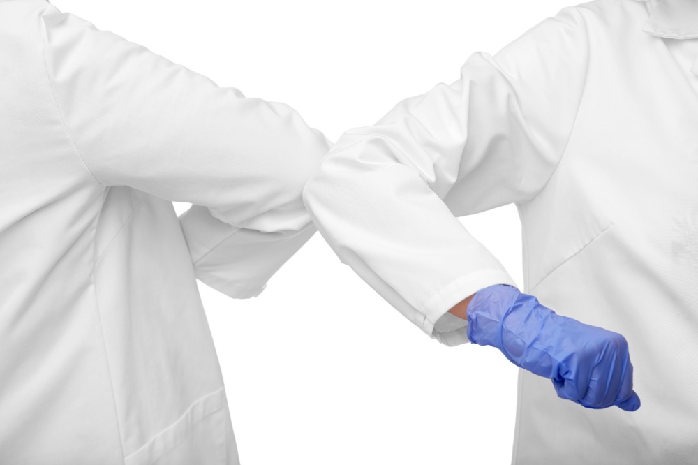 medicine, health protection and healthcare concept - close up of doctors make elbow bump greeting gesture over white background. close up of doctors make elbow bump gesture