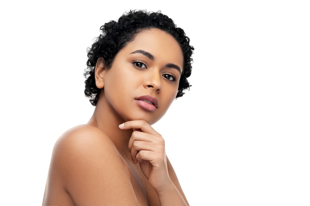 beauty and people concept - portrait of young african american woman with bare shoulders touching her face over white background. portrait of young african american woman
