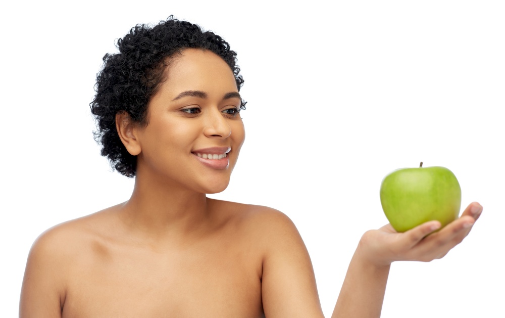 beauty, healthy eating and people concept - portrait of happy smiling african american woman holding green apple over grey background. happy african american woman holding green apple