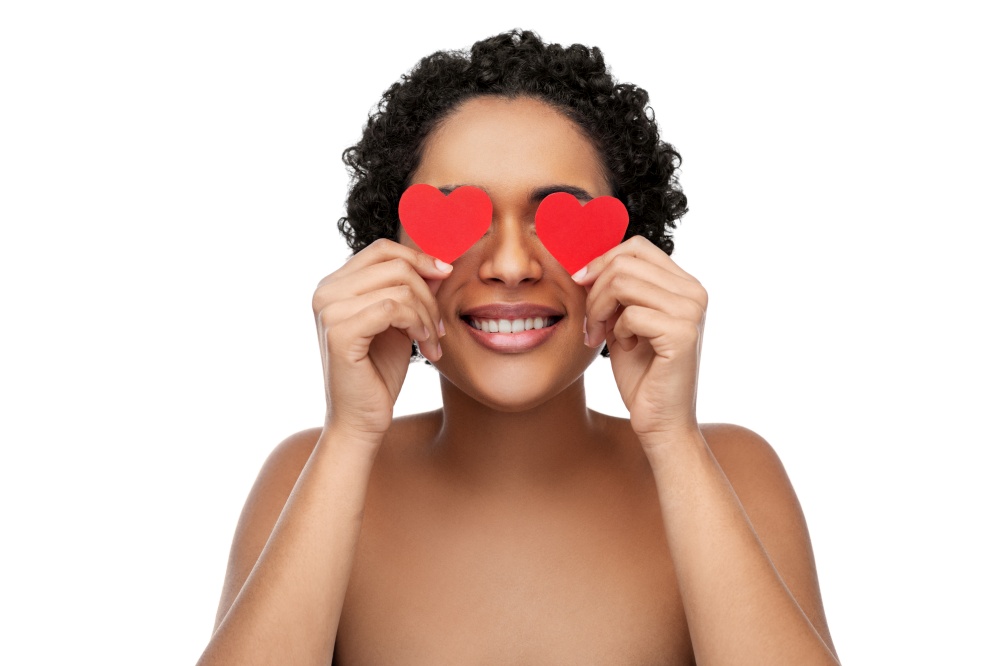 beauty, valentine&rsquo;s day and love concept - portrait of happy smiling young african american woman covering her eyes with red hearts over white background. african american woman covering eyes with hearts