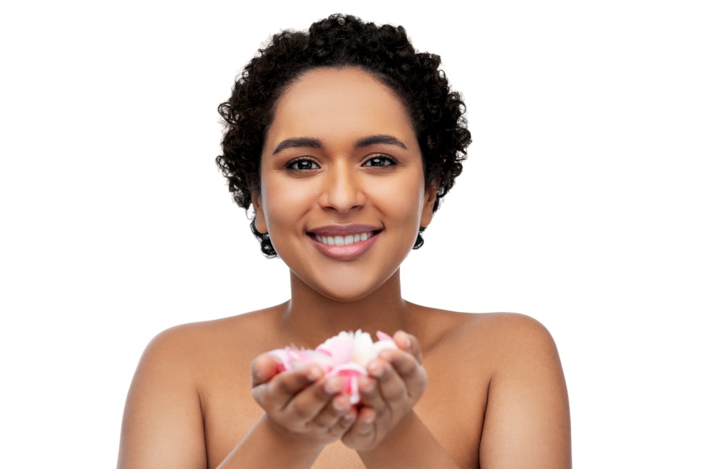 beauty and people concept - portrait of happy smiling young african american woman with flower petals over white background. young african american woman with flower petals