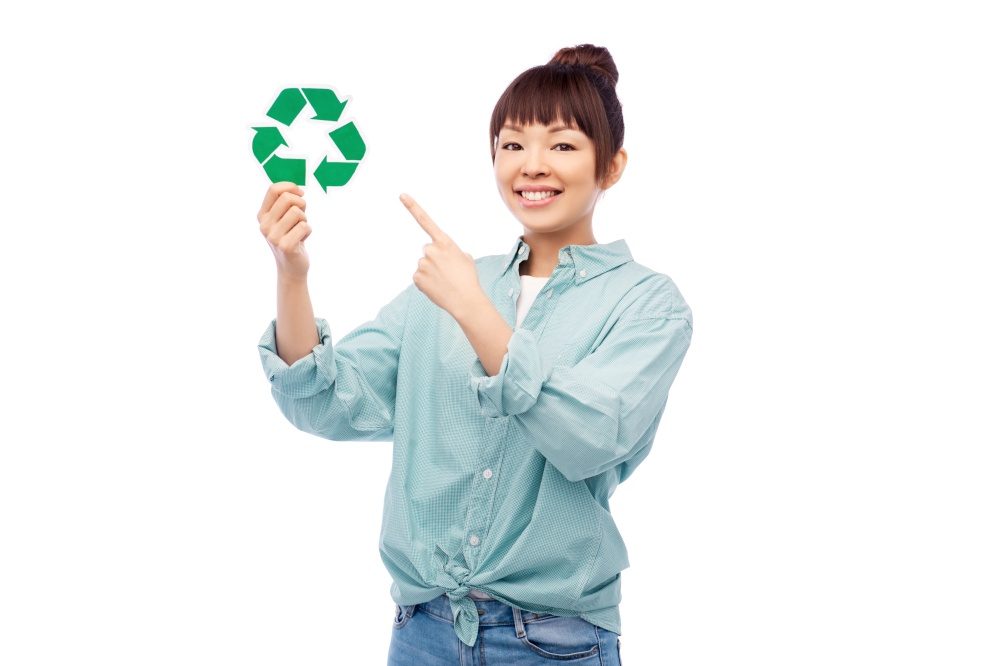 eco living, environment and sustainability concept - portrait of happy smiling young asian woman in turquoise shirt holding green recycling sign over grey background. smiling asian woman holding green recycling sign
