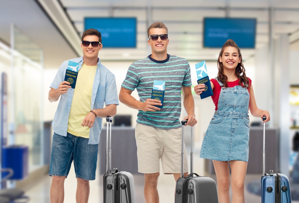 safe travel, tourism and health care concept - happy smiling young people with air tickets, immunity passports and bags over airport background. happy people with tickets and immunity passports