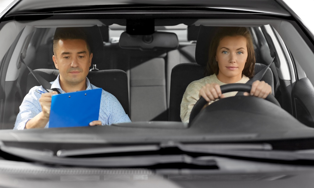 driver courses, exam and people concept - young woman and driving school instructor with clipboard in car. car driving school instructor and young driver