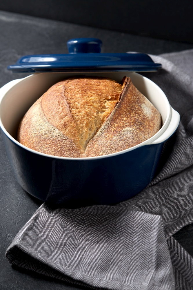 food and cooking concept - homemade craft bread in ceramic baking dish on table. homemade craft bread in ceramic baking dish
