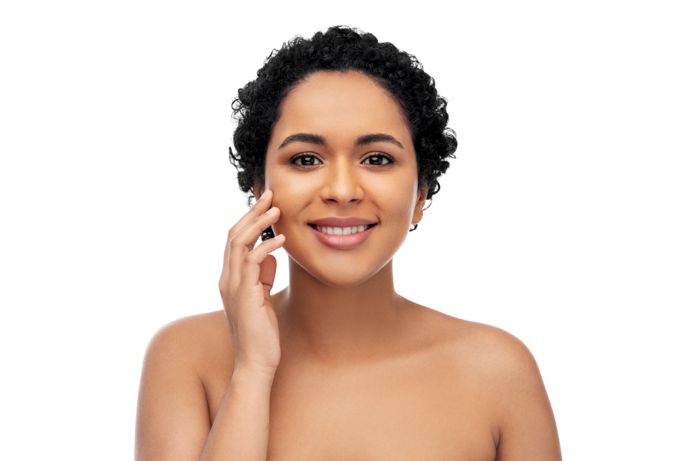 beauty and people concept - portrait of happy smiling young african american woman with bare shoulders touching her face over white background. portrait of young african american woman