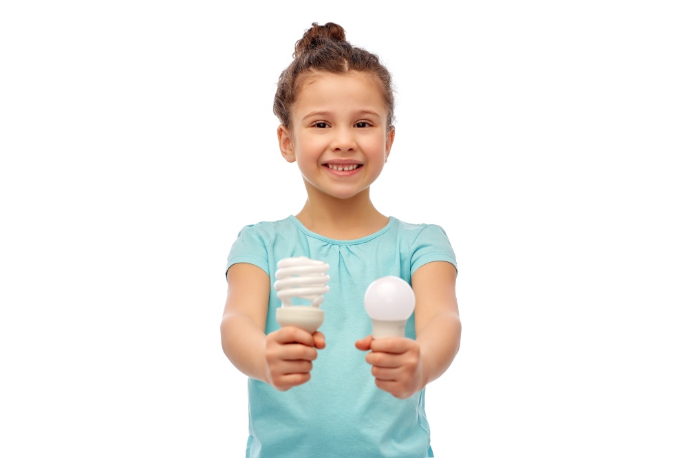 eco living and sustainability concept - smiling girl comparing energy saving light bulb with incandescent lamp over white background. smiling girl comparing different light bulbs