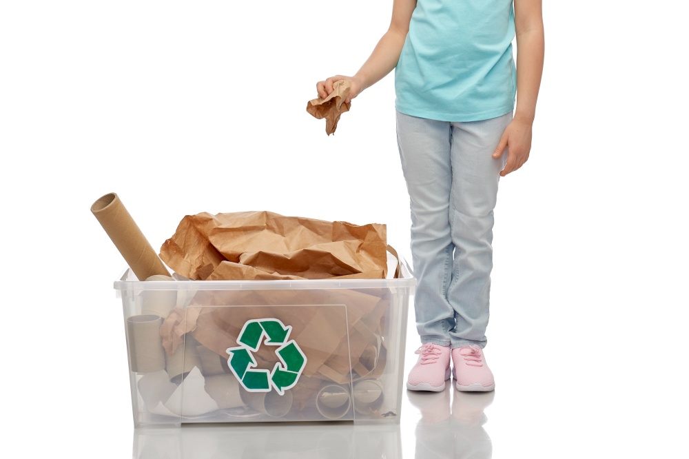 recycling, waste sorting and sustainability concept - little girl puts paper garbage in plastic box over white background. smiling girl sorting paper waste