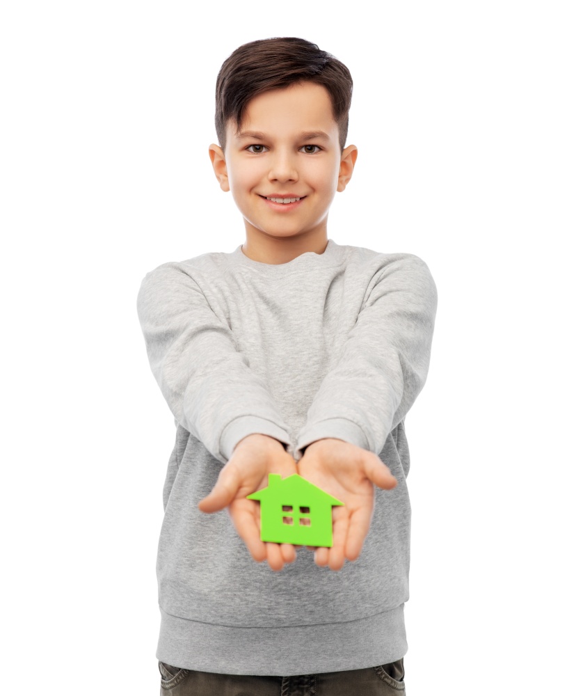 eco living, environment and sustainability concept - smiling boy holding green house icon over white background. smiling boy holding green house icon