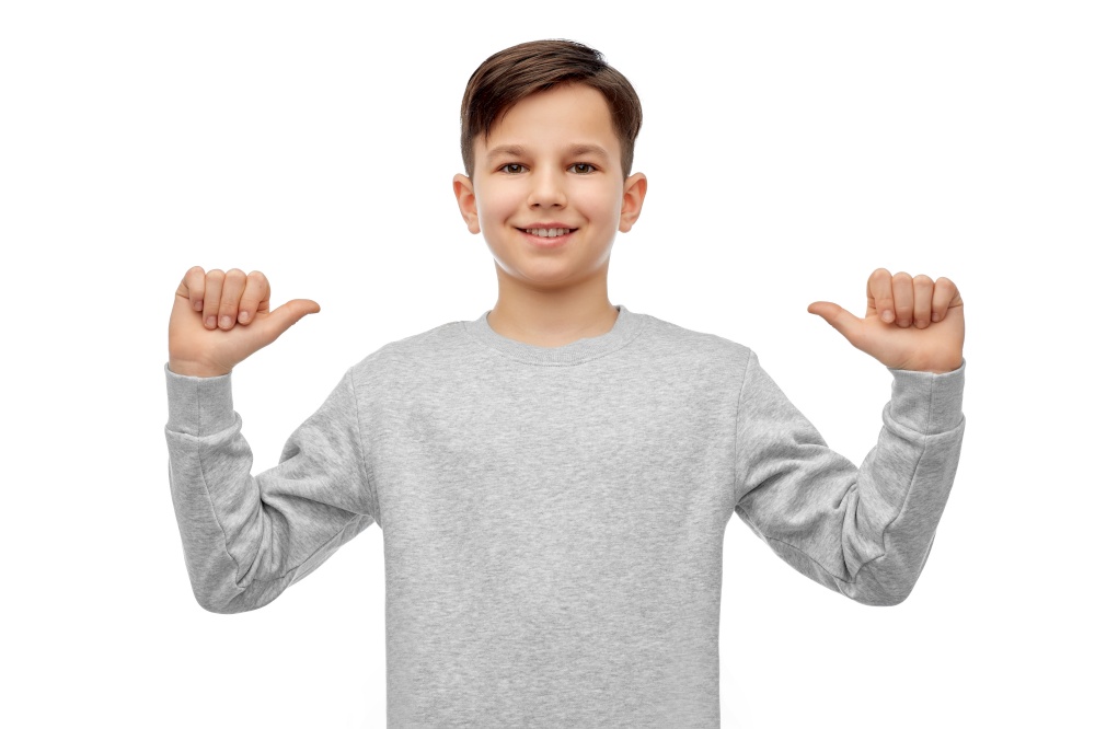 childhood, fashion and people concept - happy smiling boy pointing fingers at himself over white background. happy smiling boy pointing fingers at himself
