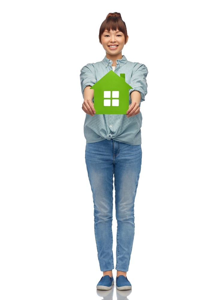 eco living, environment and sustainability concept - happy smiling young asian woman in turquoise shirt holding green house over white background. smiling asian woman holding green house